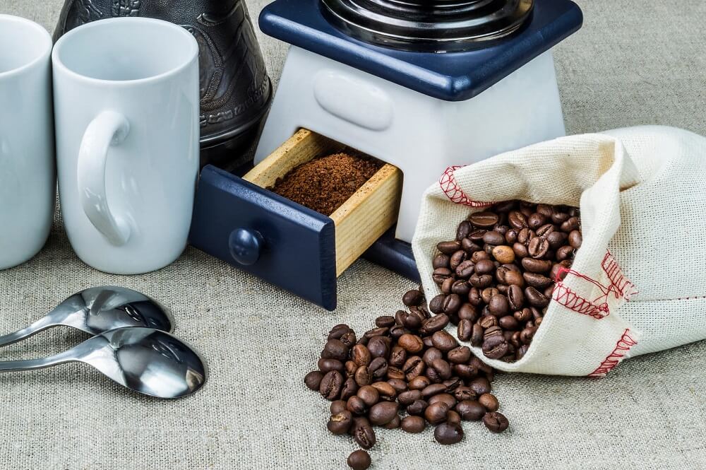 Two white cups, mill and roasted bobs coffee