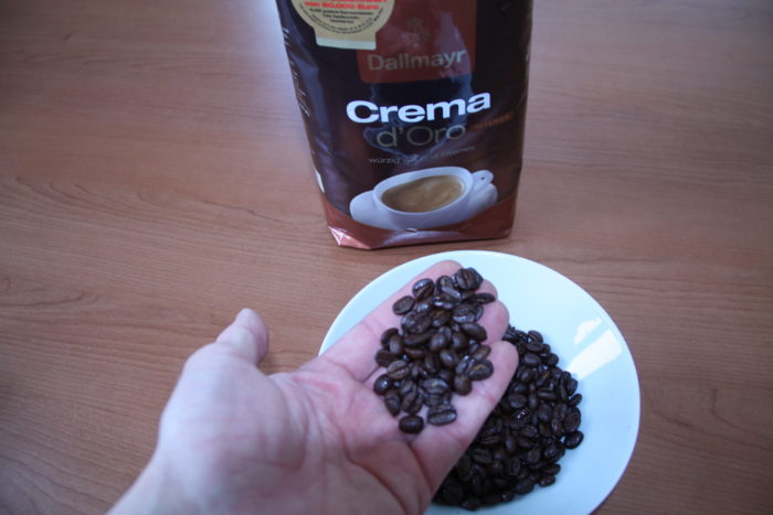Dallmayr Crema d'Oro Kaffeebohnen in der Hand