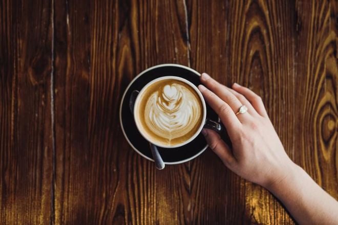Latte-Art-Frau-hält-Tasse
