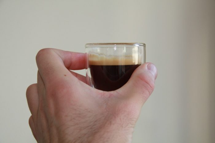 Lavazza Kaffee Test Espressoglas in der Hand