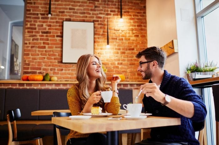 Mann und Frau lachend bei Kaffee und Kuchen