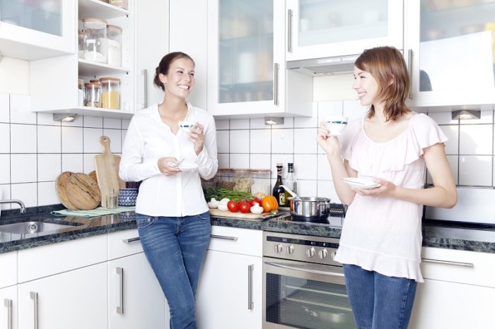 Mutter und Tochter trinken Kaffee in der Küche