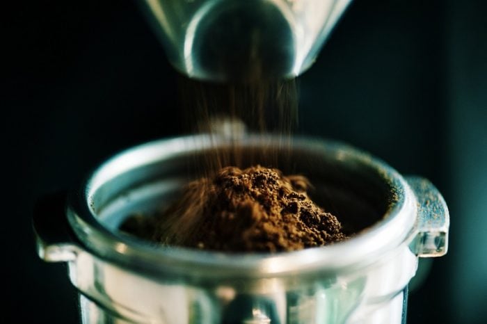 Gemahlener Kaffee wird in Siebtraeger geschuettet