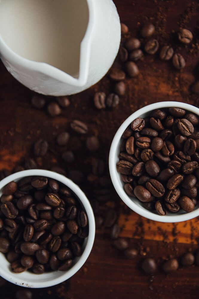 Kaffeebohnen und Kanne mit Milch