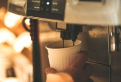 Kaffee im Pappbecher unter Kaffeevollautomat