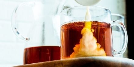 Milch wird in Tee geschüttet