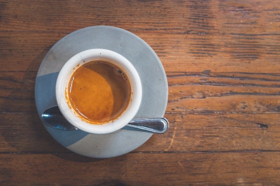 espresso in grauer tasse auf holztisch