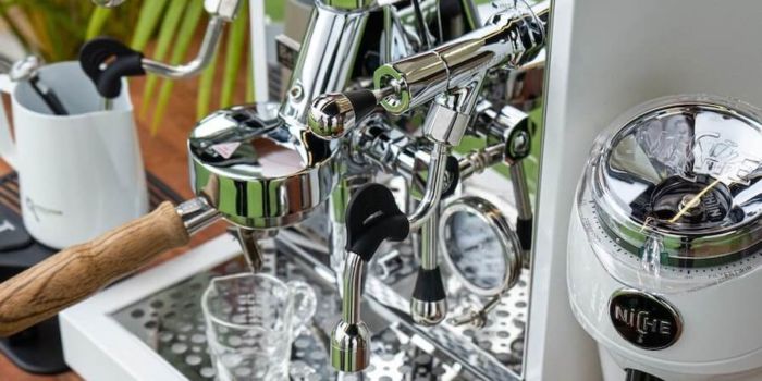 Siebträger Zweikreiser auf Holztisch neben Kaffeemühle