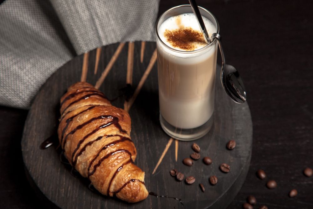 Latte Macchiato neben Croissant