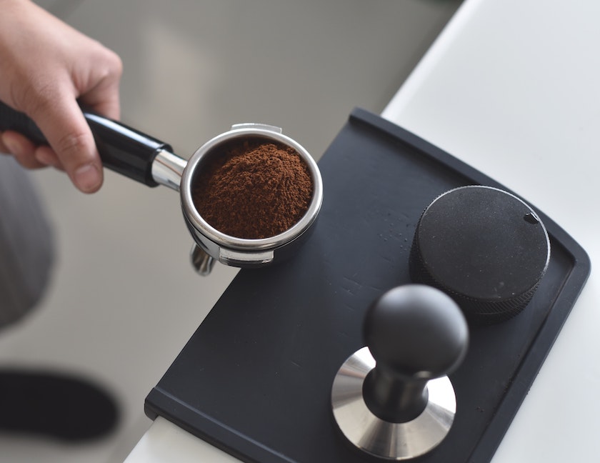 frisch gemahlenes Kaffeemehl auf Tamperstation