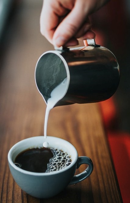 Milchkännchen und schwarzer Kaffee